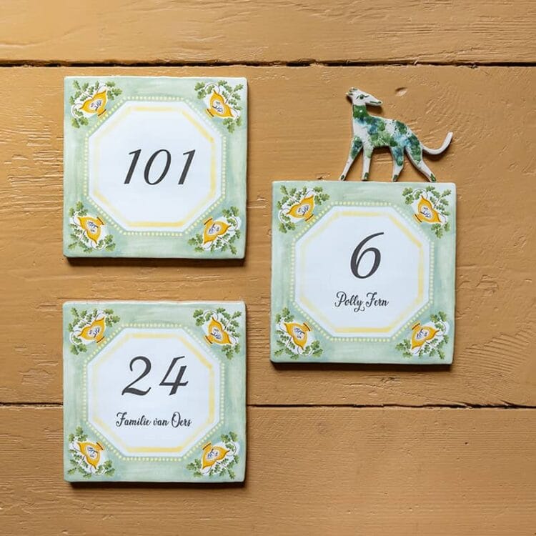 | Your house number tile designed in English style. A StoryTile always includes a hanging system, ready to hang the tile right away. If you want to use the tile as a house number, there are 2 options to ensure the tile will stick to the wall in rainy and stormy weather. You can glue the tile directly to the wall or you can purchase the hanging plate. You can find this handy accessory under Frames & Holders in the menu.